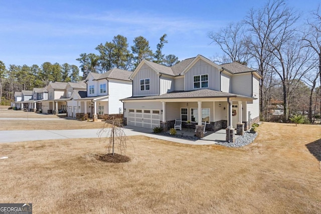 view of front of home featuring a porch, concrete driveway, a front lawn, a garage, and board and batten siding