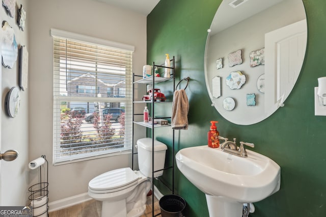 197 Stocks Cir, West Point, GA 31833 - half bath featuring toilet, wood finished floors, baseboards, and a healthy amount of sunlight
