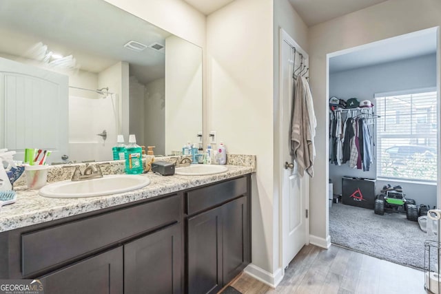 197 Stocks Cir, West Point, GA 31833 - full bathroom with walk in shower, wood finished floors, a sink, and double vanity