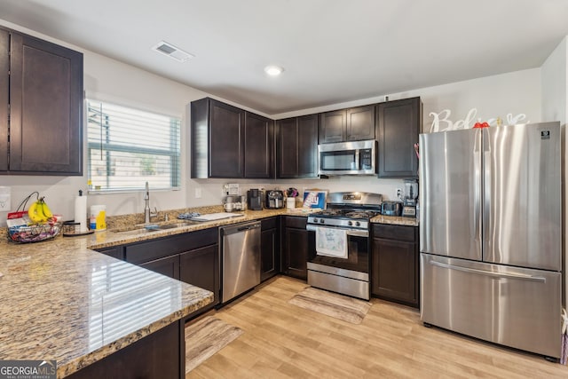 197 Stocks Cir, West Point, GA 31833 - kitchen featuring light wood finished floors, stainless steel appliances, dark brown cabinets, visible vents, and a sink