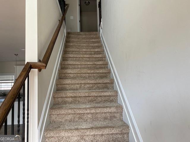 staircase featuring baseboards