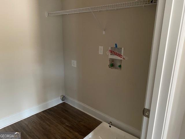 clothes washing area with baseboards, washer hookup, dark wood-style floors, and laundry area