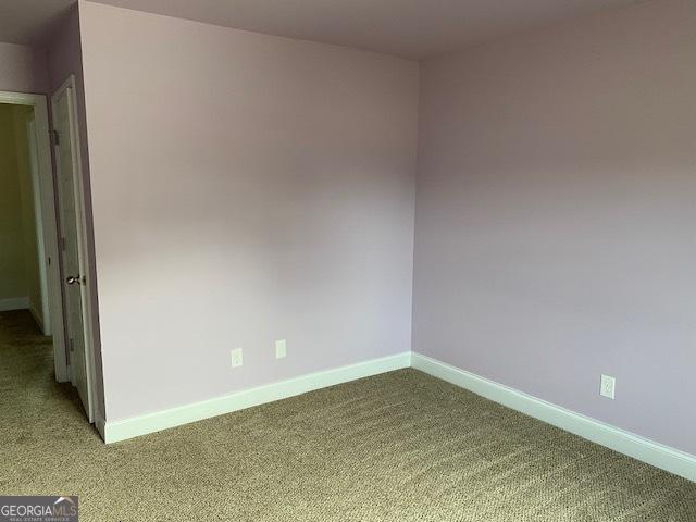 unfurnished room featuring baseboards and carpet floors