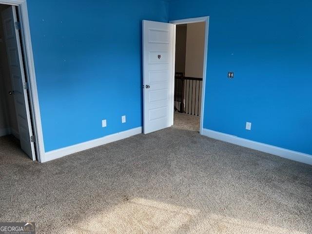 unfurnished bedroom with carpet flooring and baseboards