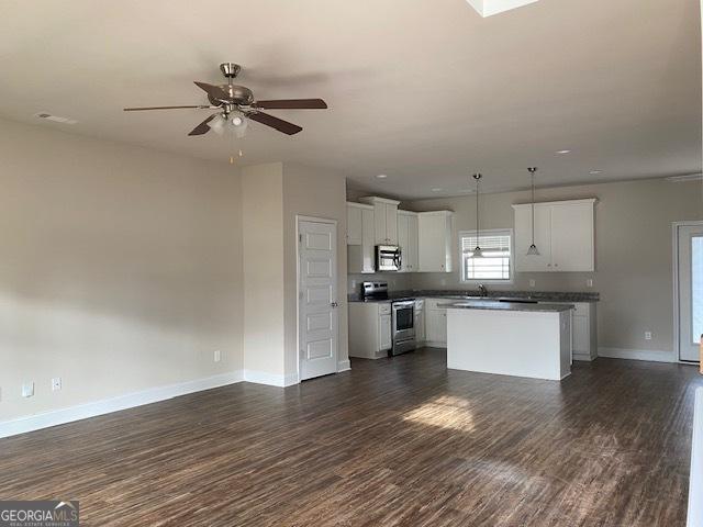 kitchen with open floor plan, appliances with stainless steel finishes, a ceiling fan, and dark wood-style flooring