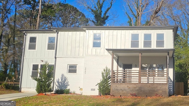 view of front of house featuring crawl space, covered porch, board and batten siding, and brick siding