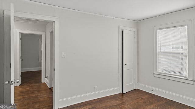 1132 Fair St SW, Atlanta, GA 30314 - unfurnished bedroom featuring dark wood-style floors, baseboards, ornamental molding, and a closet