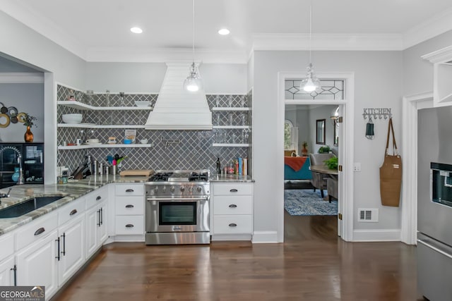 kitchen featuring light stone countertops, appliances with stainless steel finishes, custom exhaust hood, white cabinetry, and open shelves