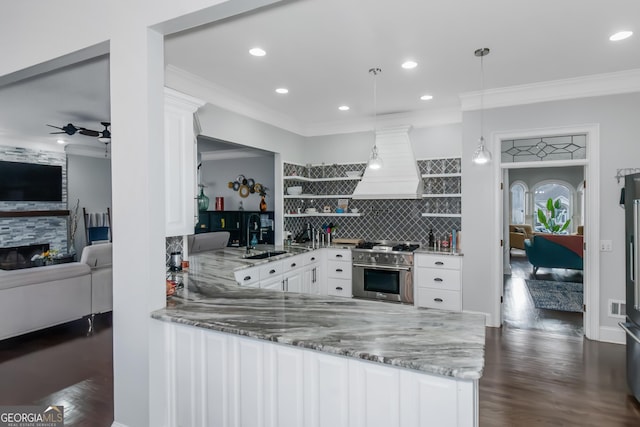 kitchen with premium range hood, open shelves, light stone counters, a sink, and high end range