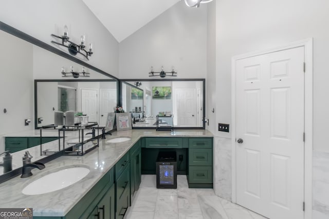 full bath featuring double vanity, marble finish floor, high vaulted ceiling, and a sink