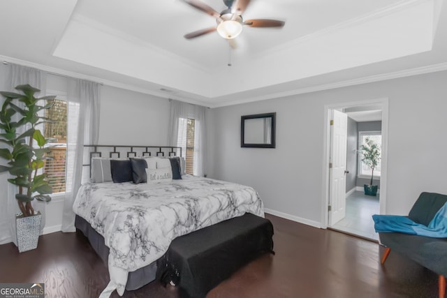 bedroom with a tray ceiling, baseboards, and dark wood-type flooring