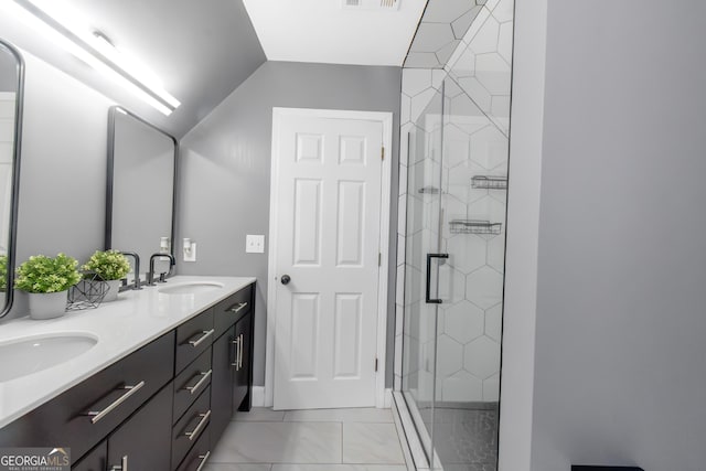 bathroom featuring a tile shower, visible vents, double vanity, and a sink