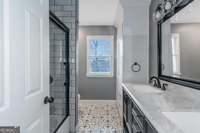 bathroom featuring walk in shower, baseboards, double vanity, tile patterned floors, and a sink