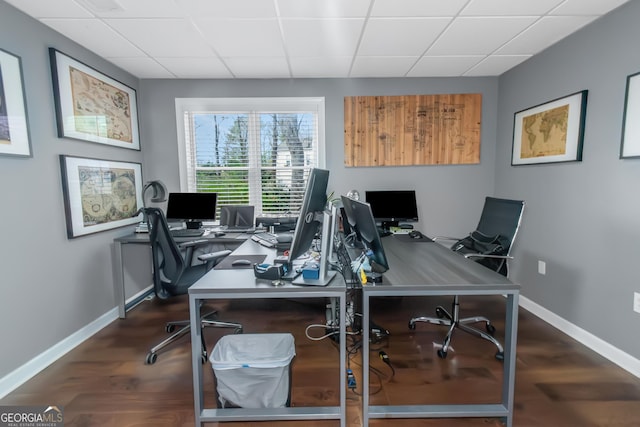 office space featuring a paneled ceiling, baseboards, and wood finished floors