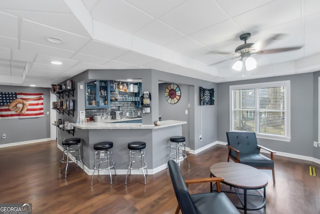 bar with indoor wet bar, decorative backsplash, baseboards, and ceiling fan