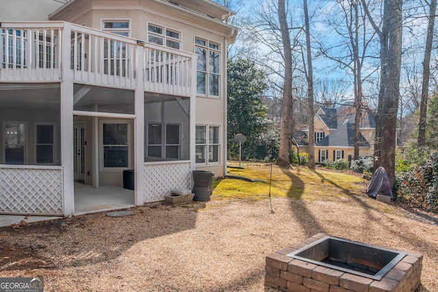 back of house featuring a patio, a balcony, and stucco siding