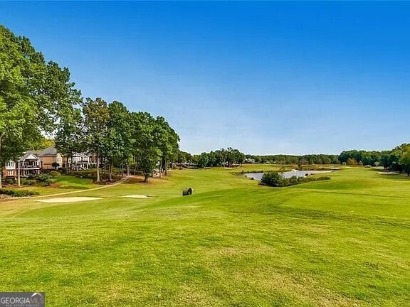 view of community with a yard and view of golf course