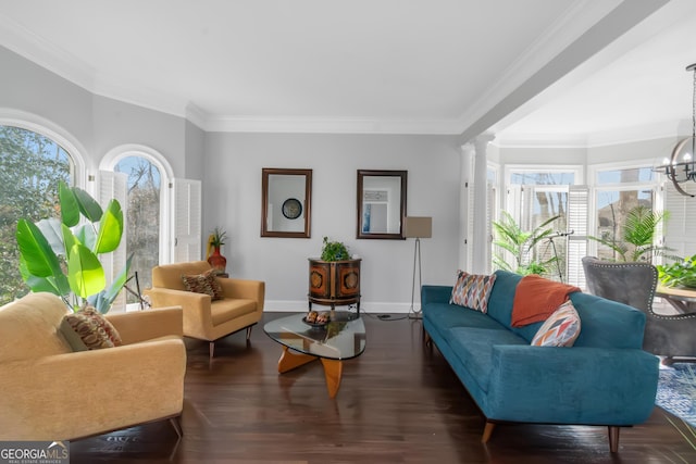 living area with wood finished floors, baseboards, decorative columns, ornamental molding, and a chandelier