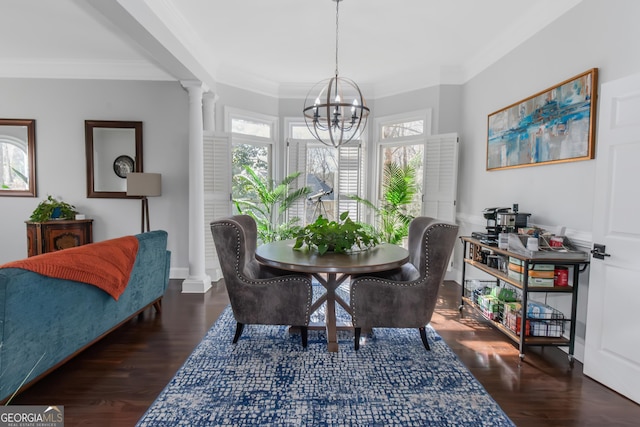 dining space featuring crown molding, decorative columns, wood finished floors, and a chandelier