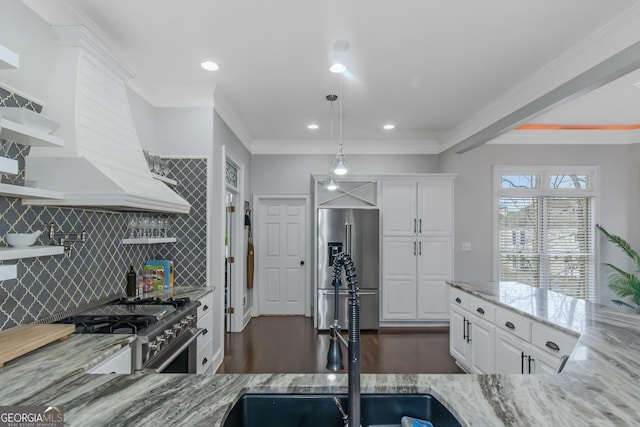 kitchen featuring light stone countertops, appliances with stainless steel finishes, white cabinets, and custom range hood