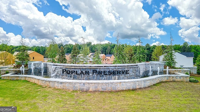 community / neighborhood sign featuring a lawn