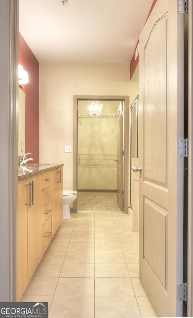 full bathroom with tile patterned floors, toilet, a stall shower, and vanity