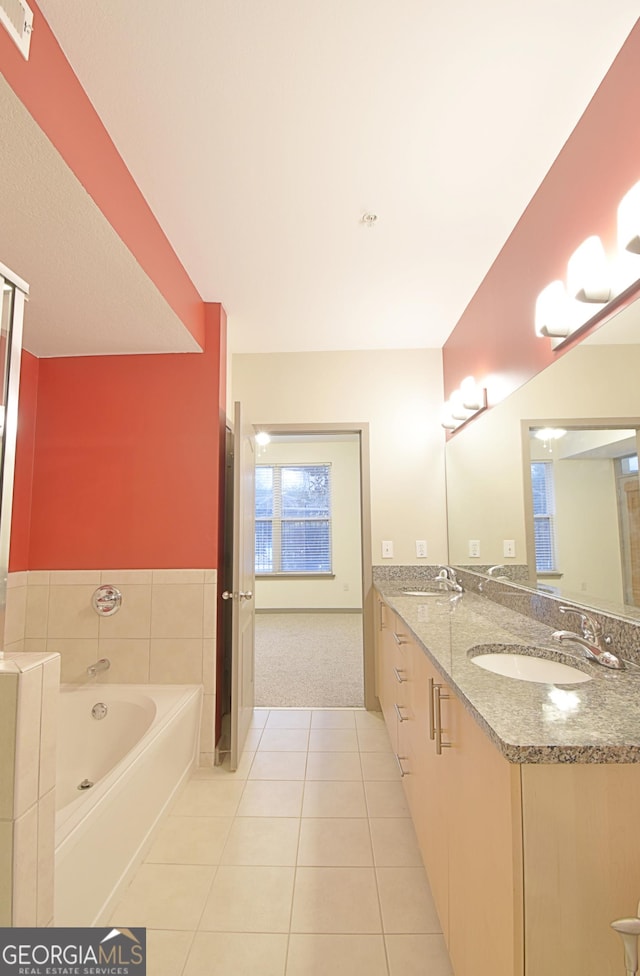 bathroom with tile patterned floors, a bath, visible vents, and a sink