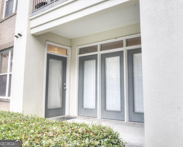 view of exterior entry with stucco siding