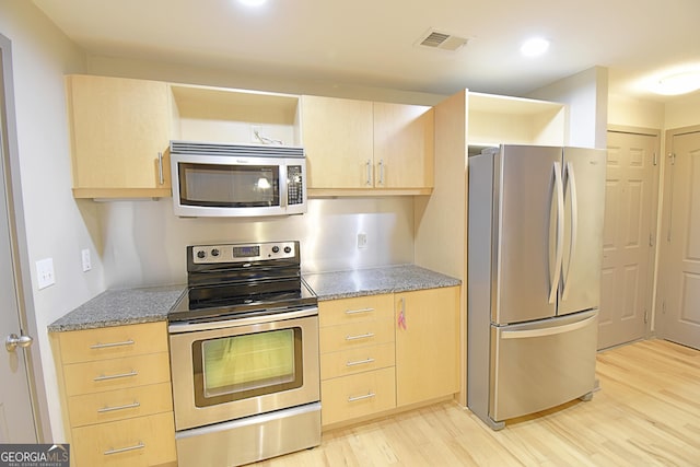 kitchen featuring light wood-type flooring, visible vents, light brown cabinetry, appliances with stainless steel finishes, and light stone countertops