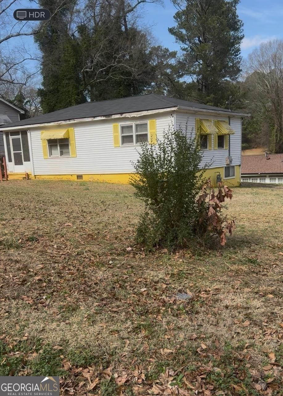 view of home's exterior featuring a lawn and crawl space