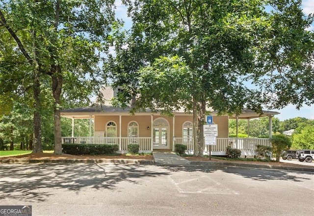 view of front of house with covered porch and french doors