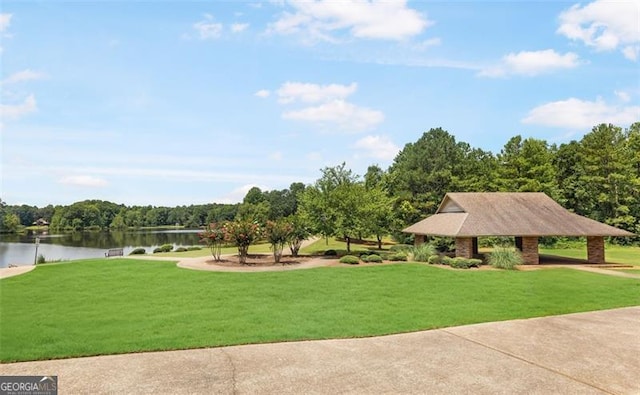 surrounding community with a lawn and a water view