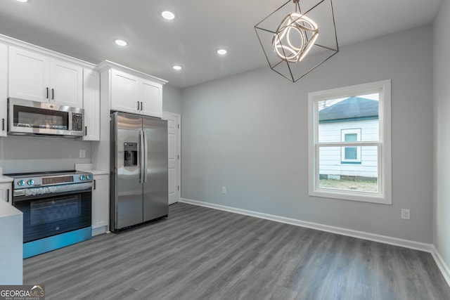 kitchen featuring wood finished floors, recessed lighting, appliances with stainless steel finishes, white cabinets, and light countertops