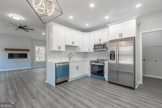 kitchen featuring white cabinetry, light countertops, light wood-style flooring, and stainless steel appliances