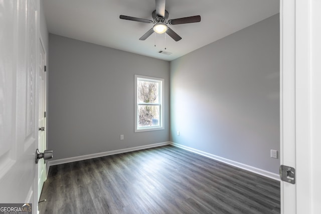 empty room featuring visible vents, ceiling fan, dark wood-type flooring, and baseboards