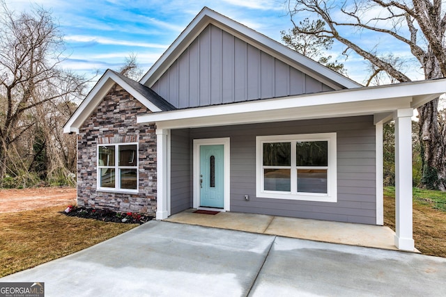 view of front facade featuring a porch, board and batten siding, and stone siding