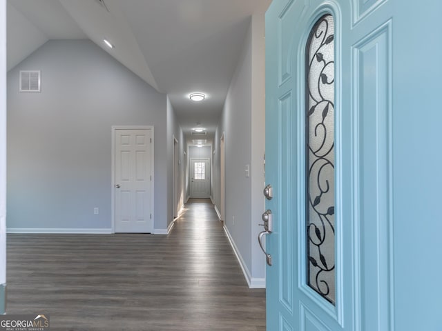 entryway featuring dark wood-type flooring, baseboards, visible vents, and lofted ceiling