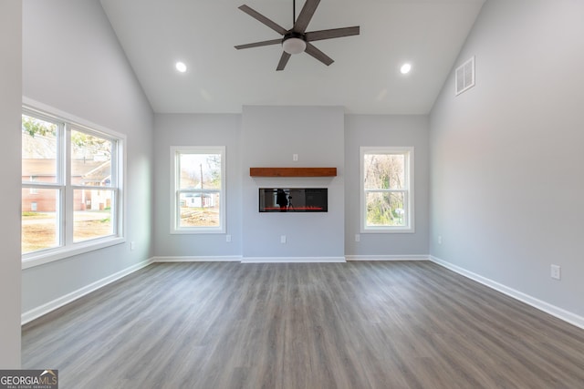 unfurnished living room featuring wood finished floors, visible vents, baseboards, and ceiling fan