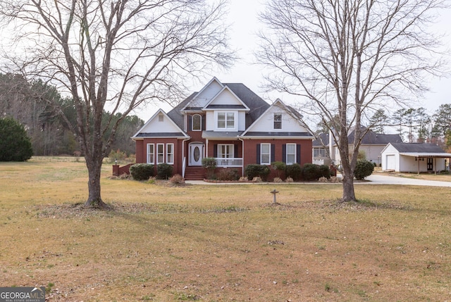 view of front facade with brick siding, a front yard, and driveway