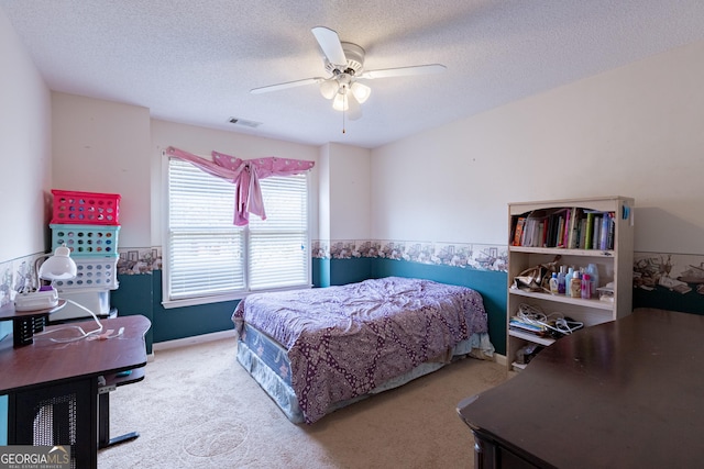 carpeted bedroom featuring baseboards, visible vents, a textured ceiling, and ceiling fan