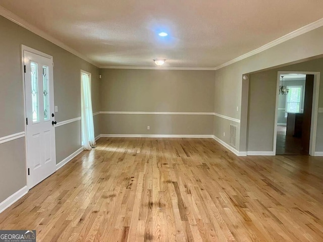 unfurnished room with ornamental molding, baseboards, light wood-style floors, and visible vents