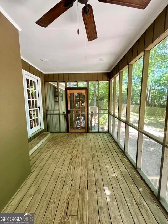 unfurnished sunroom with ceiling fan