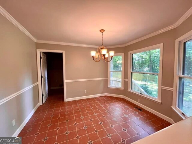 unfurnished dining area with baseboards, an inviting chandelier, and crown molding