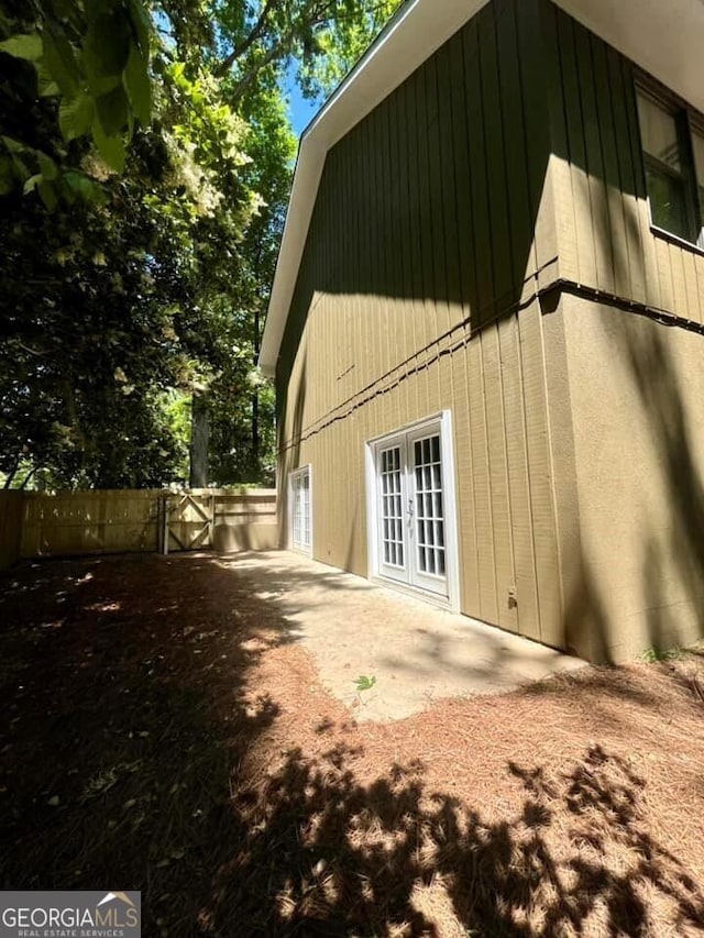exterior space with a gate, fence, french doors, and a patio area