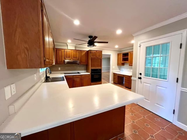 kitchen featuring ornamental molding, under cabinet range hood, a sink, ceiling fan, and black appliances