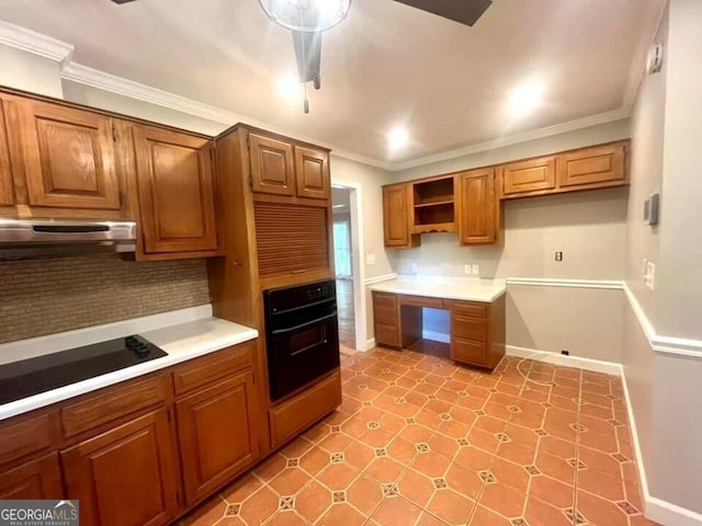 kitchen with under cabinet range hood, ornamental molding, tasteful backsplash, and black appliances