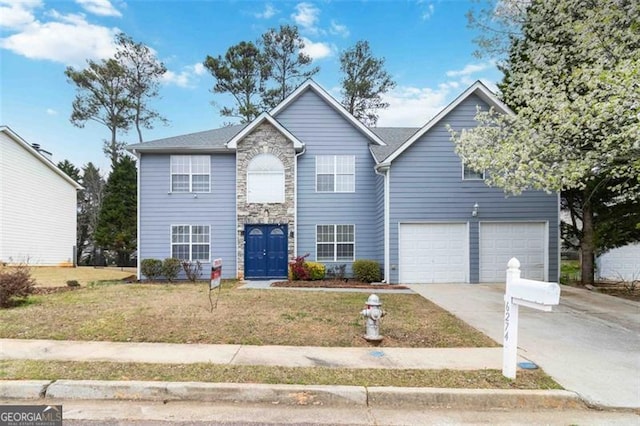 traditional-style house with stone siding, a front yard, concrete driveway, and an attached garage