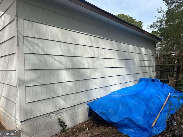 view of side of home featuring fence