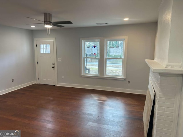 foyer entrance with a wealth of natural light, visible vents, dark wood-style floors, and a ceiling fan