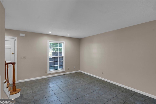 spare room featuring recessed lighting and baseboards